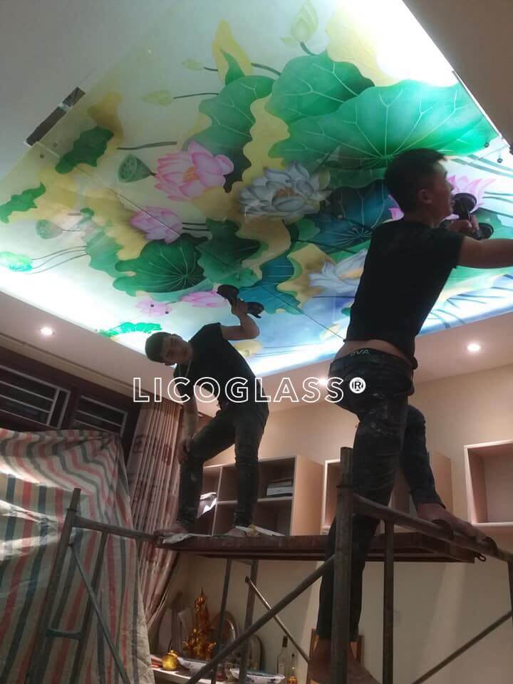 Thi công vách ốp trần bằng kính cường lực điêu khắc hoa sen 3D, dưới ánh đèn hình ảnh bông hoa hiện lên thật lung linh, ấn tượng, mang lại vẻ đẹp nổi bật cao cấp cho không gian căn phòng Mẫu tranh kính đẹp