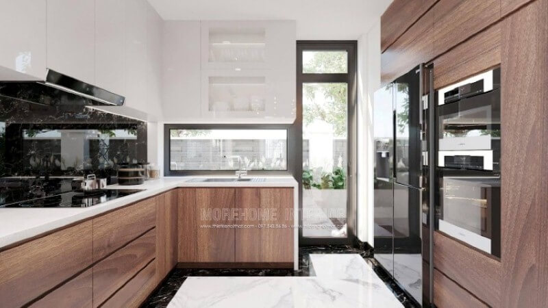 Trong thiết kế không gian phòng bếp biệt thự hiện đại, vật liệu ốp bếp rất được chú trọng bởi điều hiển nhiên xảy ra khi nấu nướng sẽ có nhiều vết bắn dầu mỡ nếu không được lau sạch sẽ gây ra ẩm mốc. Khắc phục điều đó, kính ốp bếp hay đá ốp bếp đều là lựa chọn tối ưu, nhưng nếu có điều kiện đá ốp bếp nhân tạo màu đen chỉ trắng như trong mẫu phòng bếp trong đây sẽ là lựa chọn tuyệt vời. Đá nhân tạo
