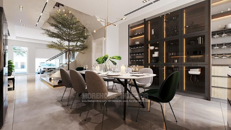 Trang trí nội thất phòng ăn đẹp với bộ bàn ăn dành cho 8 thành viên, chiếc đèn thả trần nghệ thuật, gạch lát nền giả đá màu nâu cao cấp, tủ gỗ kết hợp kính có gắn đèn led để đồ hiện đại. Thiết kế phòng ăn tại Hà Nội